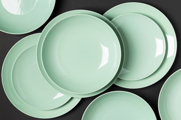 Foto gratuita composizione di piatti di diverse dimensioni su sfondo nero