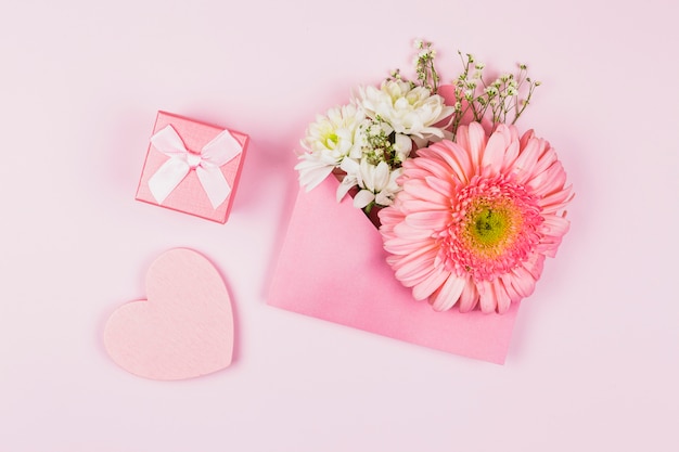 Composition of fresh flowers in envelope near present and ornamental heart