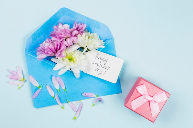 Composition of fresh flowers with tag in envelope near present