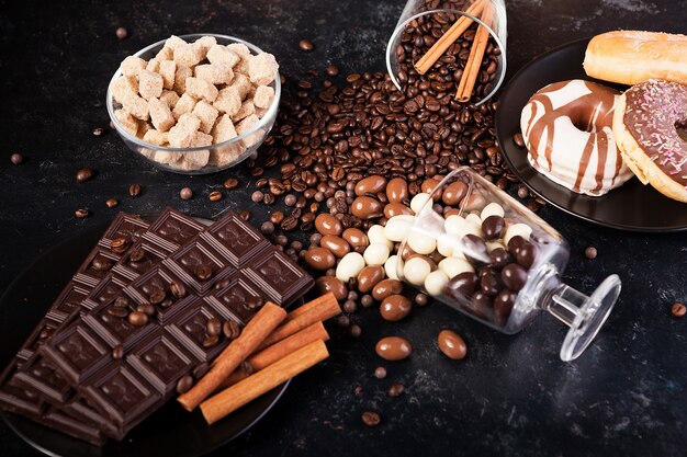 Composition from different type of candies on dark wooden background