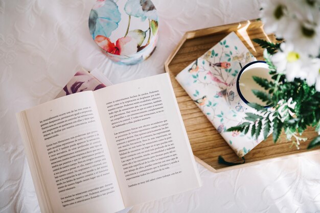 Composition from opened book and wooden tray