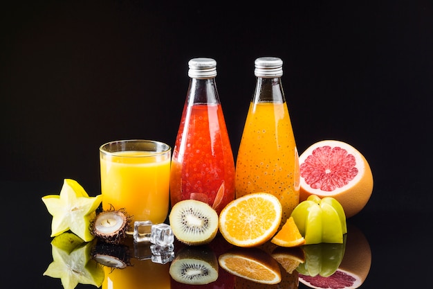 Composition of fruit and juices on black background