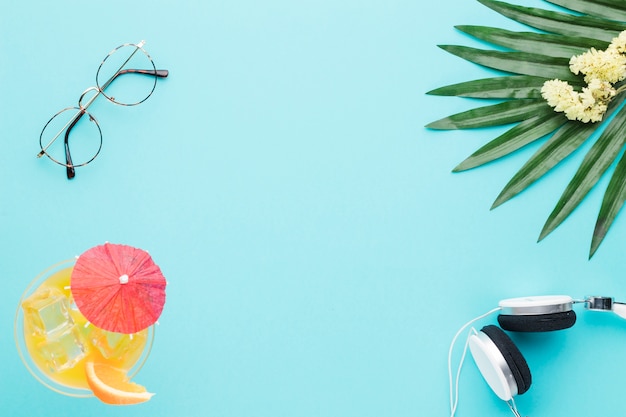 Free photo composition of glasses cocktail earphones leaf and flowers