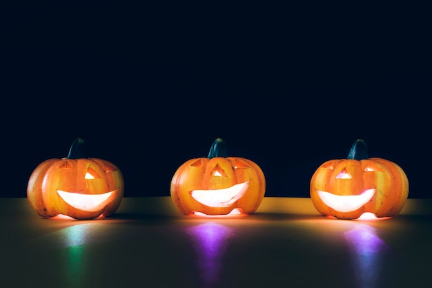 Composition for halloween with three illuminated pumpkins