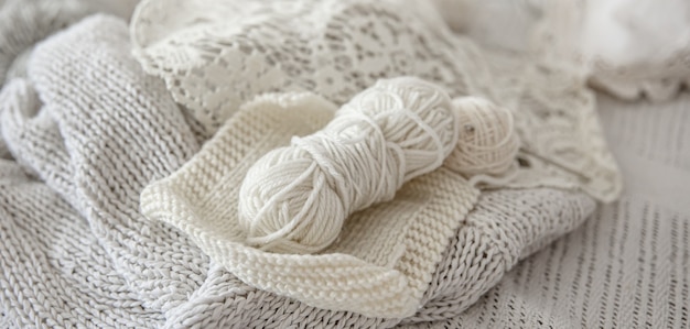 Composition of handmade knitted products and threads in pastel colors.