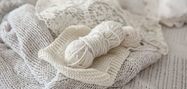 Composition of handmade knitted products and threads in pastel colors.