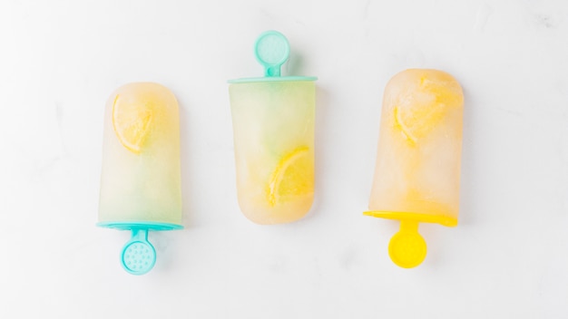 Composition of ice popsicle with citrus on colorful sticks