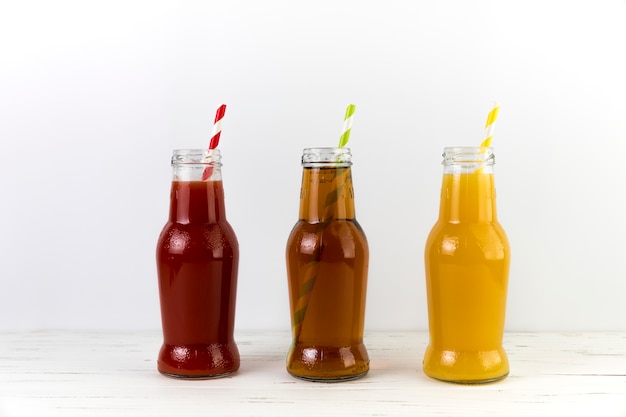 Free photo composition of juice bottles with straws