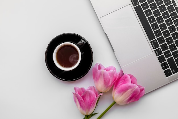 Композиция из ноутбука с тюльпанами и чашка кофе