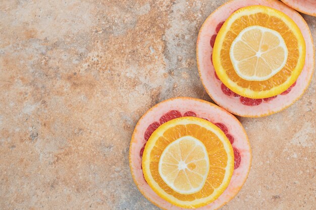 Композиция из ломтиков лимона, апельсина и грейпфрута. Фото высокого качества