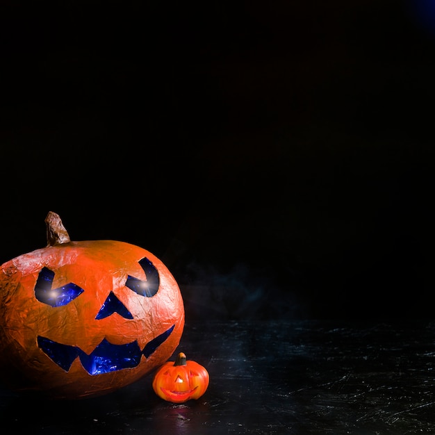 Composition pumpkin with blue carved face glowing