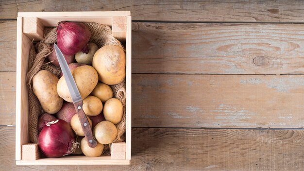 Composition of raw potatoes in wooden box with copy space