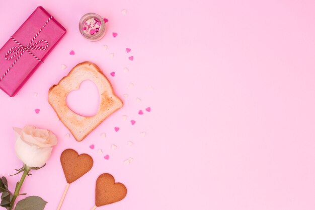 Free photo composition of rose with heart-shaped cookies