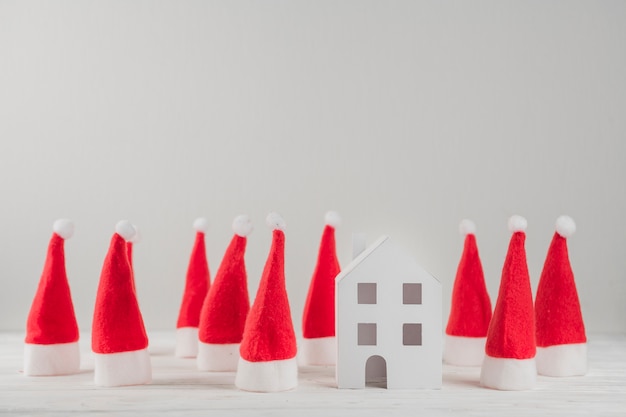 Foto gratuita composizione di cappelli di santa e casa del giocattolo