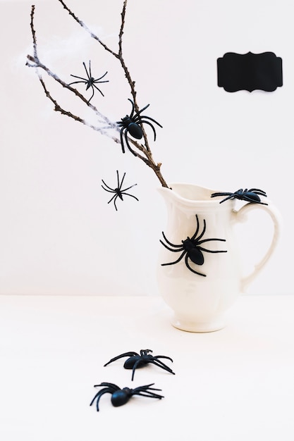 Composition of spiders and jug with branch