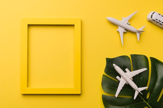 Composition of toy jets bus yellow frame and plant leaf