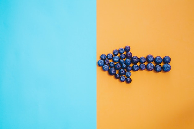 Free photo composition with arrow of blueberries