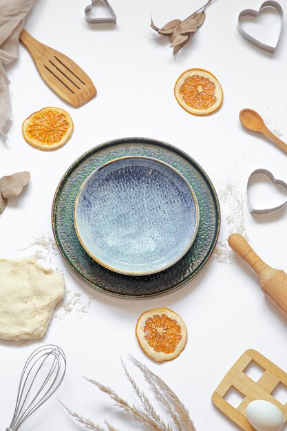 Free photo composition with baking ingredients and kitchen accessories on a white table top view.