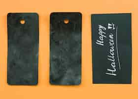 Free photo composition with black cards and happy halloween inscription