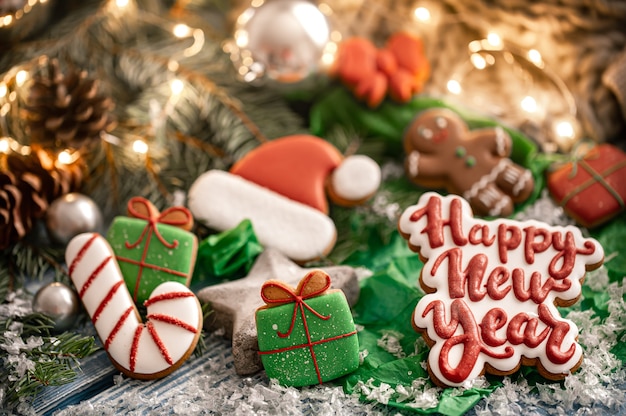 Composition with bright Christmas glazed gingerbread cookies on a blurred background with bokeh. Craft homework cookies for Christmas.