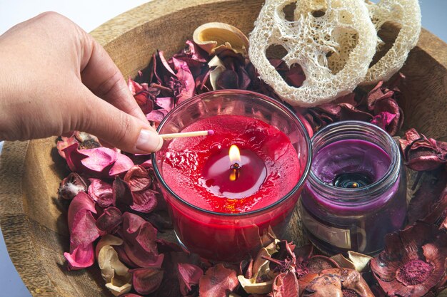 composition with burning aroma candles among rose petals