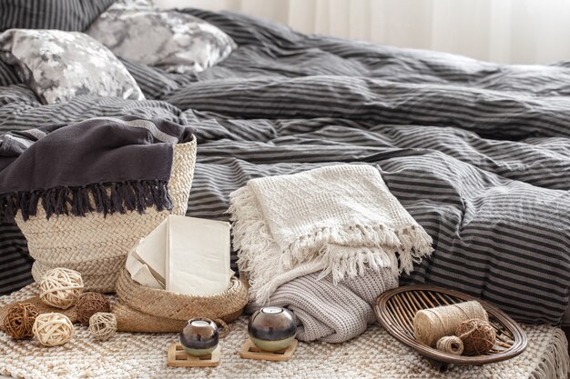 Composition with candles, knitted elements and other decor details in the bedroom.