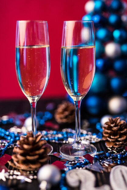 Composition with Christmas and New Year 2020 decorations and two champagne glasses, on bright background