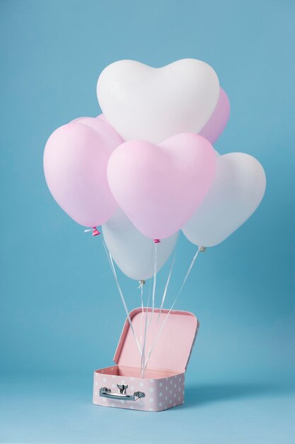 Composition with cute heart balloons in a box