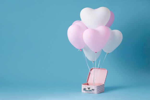 Composition with cute heart balloons in a box