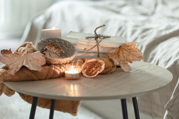 Composition with details of autumn decor on the table in the interior of the room.