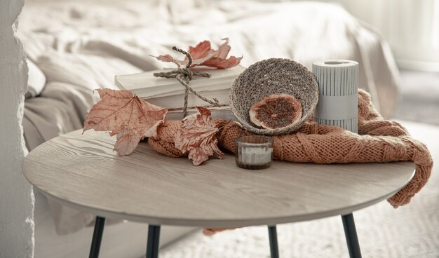 Composition with details of autumn decor on the table in the interior of the room.
