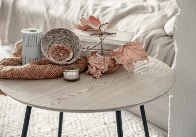 Composition with details of autumn decor on the table in the interior of the room.