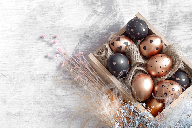 Composition with Easter eggs painted in gold and black colors with ornaments