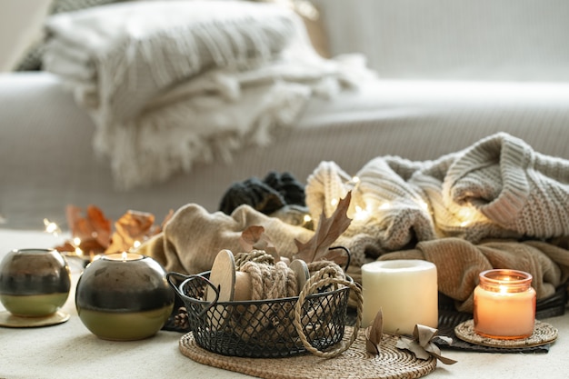 Composition with many candles, decorative rope on the space of the room in warm colors.