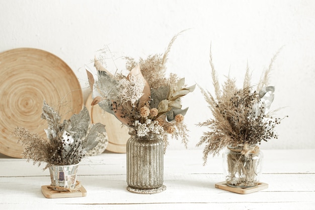 Composition with many dried flowers in vases .
