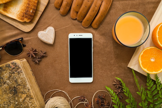 Foto gratuita composizione con telefono cellulare e succo d'arancia per il giorno del padre