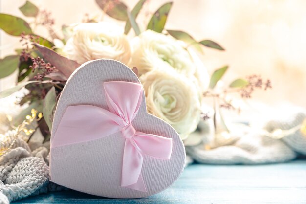 Free photo composition with a pink heartshaped gift box and flowers