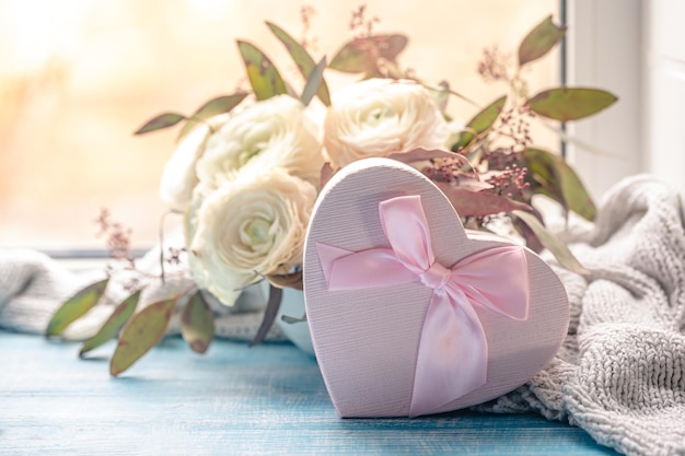 Free photo composition with a pink heartshaped gift box and flowers