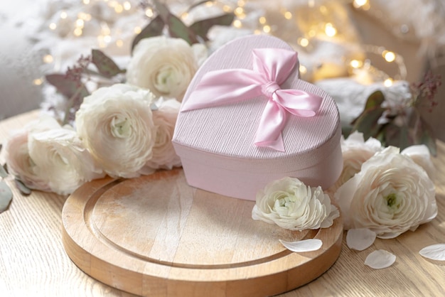 Free photo composition with a pink heartshaped gift box and flowers