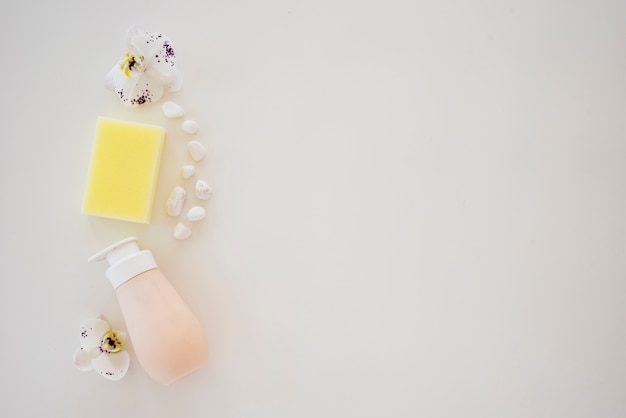 Free photo composition with soap bottle pebble and orchids