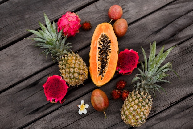Foto gratuita composizione con frutti tropicali sulla superficie in legno