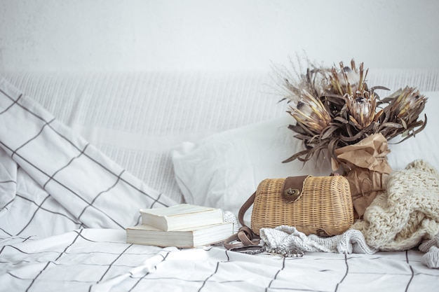 Composition with a wicker handbag, books and a bouquet of dried flowers copy space