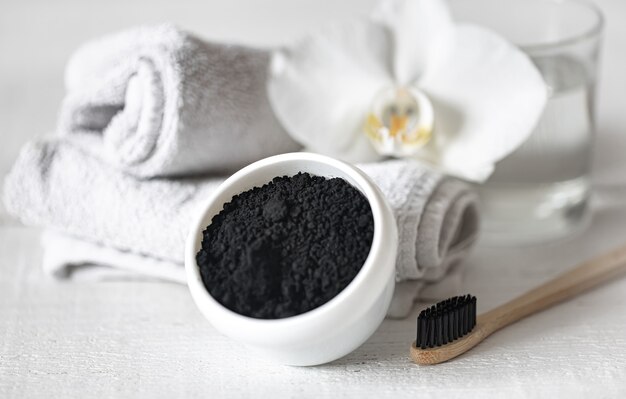 Composition with wooden natural toothbrush and black powder for teeth whitening.