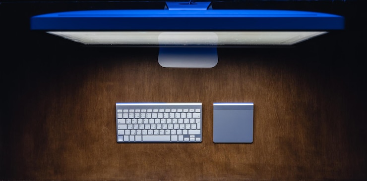 Free Photo computer and keyboard on a wooden table at night top view