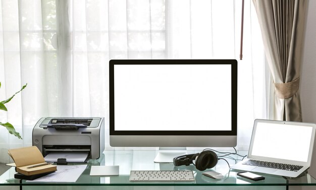 Computer, laptop and printer on a desk