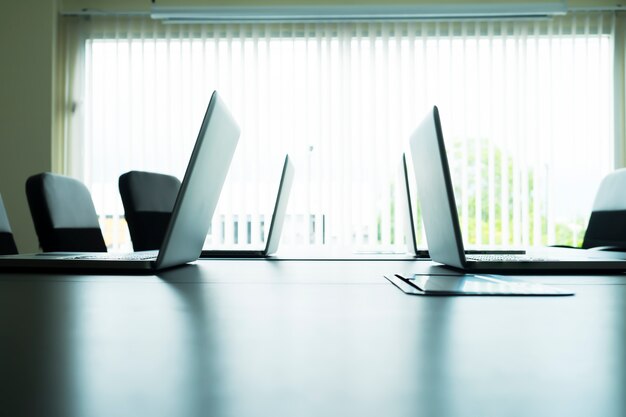 Computer laptops on table in meeting room.