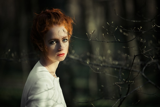 Free photo conceived redheaded girl with red lips looking into the frame