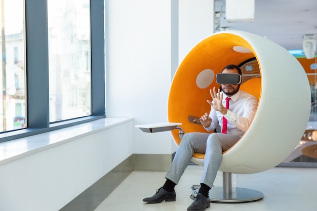 Concentrated African American user wearing VR glasses