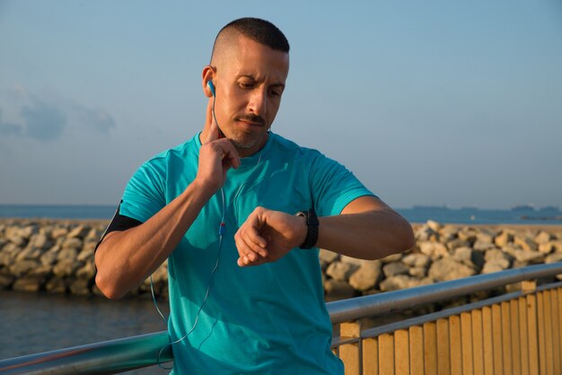 Concentrated athlete checking pulse after jogging