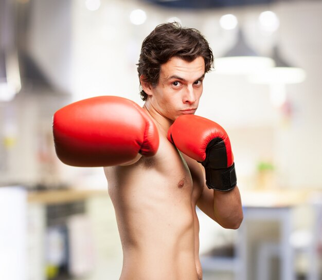 Concentrated boy training with boxing gloves